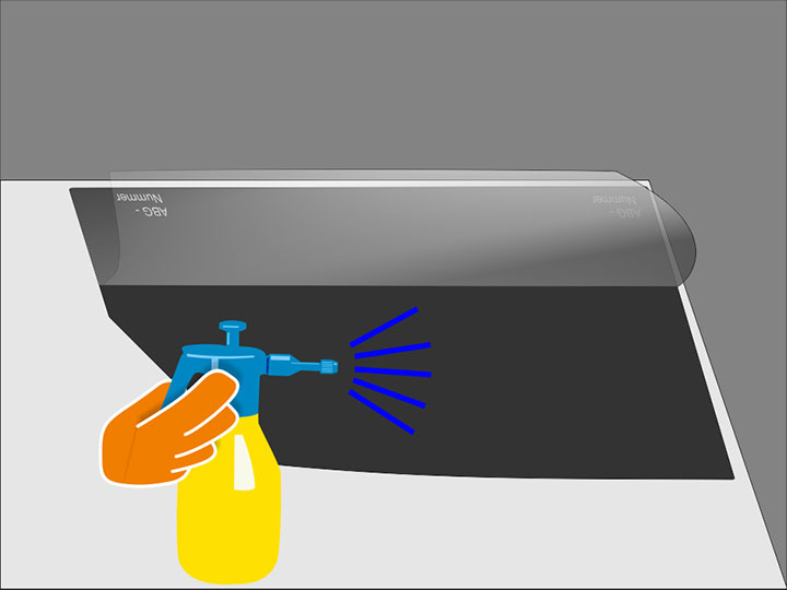 Besprühe nun die frei gelegte Klebeschicht der Folie mit ausreichend Montageflüssigkeit. Es sollte danach keine trockene Stelle mehr in der Klebeschicht geben. Besprühe anschließend auch die Innenseite der Scheibe ganzflächig mit Montageflüssigkeit. Achte darauf, dass es insbesondere an der oberen Kante keine trockenen Stellen mehr gibt.